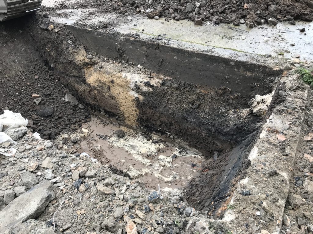 hole dug into ground as part of remediation and verification process
